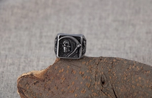 Vue détaillée d'une bague faucheuse vintage avec gravures complexes sur métal sombre