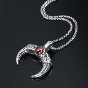 Vintage titanium steel Mayan horn pendant necklace with red gemstone on black surface