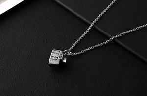 Detailed close-up of a silver vintage camera pendant necklace with artistic textures