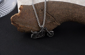 Detail macro view of vintage motorcycle pendant on a sturdy steel wheat chain