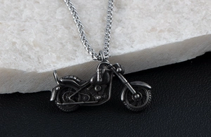 Close-up of retro motor pendant with detailed engine parts on a heavy wheat chain