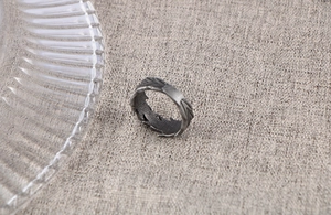 Macro shot of retro silver steel ring featuring detailed vintage feather texture engraving