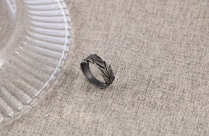 Close-up of vintage oxidized titanium steel ring with engraved feather texture