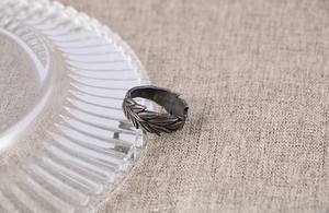 Detailed macro view of vintage oxidized steel ring with carved laurel leaf texture
