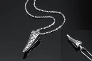 Macro view of silver antelope horn pendant with detailed V-shaped textured grooves