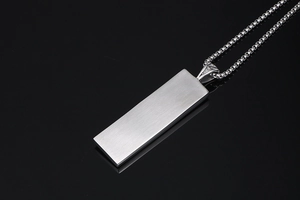Close-up of vintage square pendant with brushed silver finish on a box chain