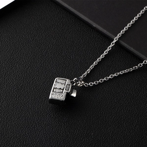 Polished silver camera pendant necklace in stainless steel on black leather background