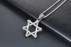 Dettaglio macro della collana a esagramma argento con trama scheletrica su pelle nera