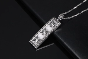 Macro detail of retro square star pendant with embossed beads and box chain necklace