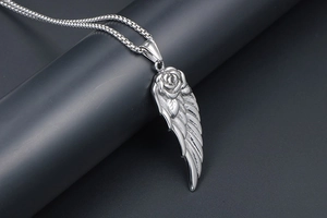 Vue rapprochée du collier pendentif rose et aile sur une chaîne à billes