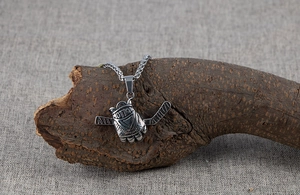 Détail du pendentif gant de hockey en acier avec gravure MOTION sur fond en bois naturel