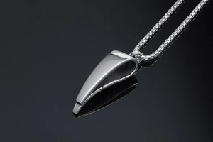 Macro shot of polished silver antelope horn pendant on a box chain for men