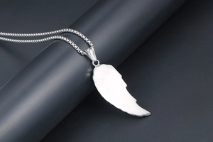 Vue détaillée du pendentif plume en argent brossé sur une chaîne à maillons fins