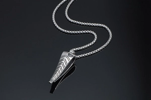 Detailed view of silver antelope horn pendant with V-shaped texture on box chain