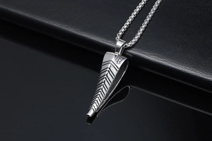 Macro detail of polished stainless steel antelope horn pendant on a silver box chain