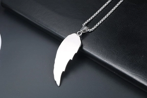 Détail du collier pendentif aile d'ange argenté avec texture métal brossé et chaîne à maillons