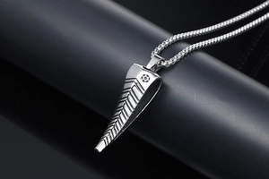 Macro shot of silver antelope horn pendant with textured stripes on titanium chain
