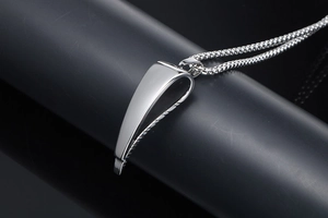 Detail view of the polished silver stainless steel antelope horn pendant on a box chain