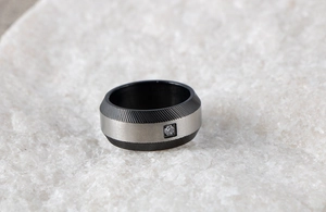 Macro detail of men's steel ring with black sandblasted texture and square zircon