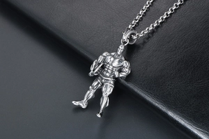 Gros plan détaillé d'un collier pendentif homme musclé en argent sur texture cuir noir