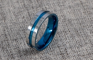 Detail view of the silver steel ring with blue inner groove and polished metal texture