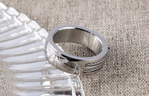 Macro detail of men's wide stainless steel ring with double steel cable inlay and polished edges