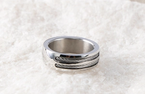 Macro shot of silver stainless steel wide band ring with dual steel wire cable design