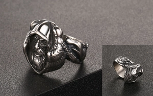Macro detail of retro titanium steel ring featuring a carved elder face and feather patterns