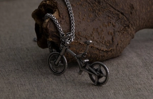 Macro view of vintage titanium steel bicycle pendant on natural wood display stand