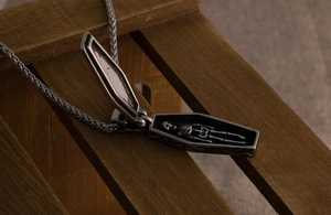 Close-up of gothic coffin necklace with opening lid and hidden skeleton inside