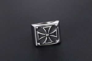Macro detail of men's stainless steel ring featuring a square face and embossed iron cross