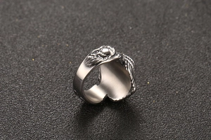 Macro shot of silver eagle wing steel ring with detailed feathers on black background