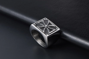 Macro shot of men's stainless steel signet ring with engraved black Maltese cross