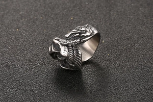 Detailed view of vintage titanium steel ring featuring dual wolf head relief and oxidized finish