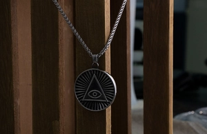 Détail macro du pendentif œil de la providence en acier titane avec textures radiales
