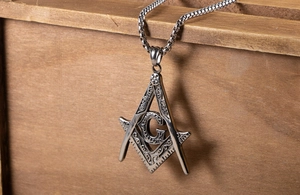 Detailed close-up of a silver titanium steel Freemasonry pendant with G symbol