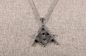 Detailed macro view of retro stainless steel Freemasonry G pendant with vine textures