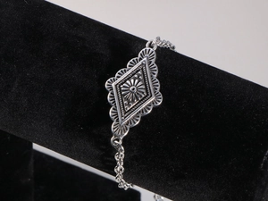 Dettaglio del ciondolo a rombo bohémien con motivo a raggiera su catena in argento vintage