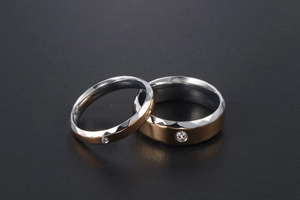 Détail de bagues de couple avec bords en or martelé et un zircon étincelant au centre