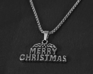 Vue macro du pendentif de Noël en acier inoxydable argenté avec gravure Merry Christmas