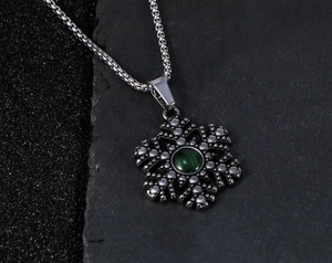 Detail van de sneeuwvlokhanger met groene kattenoogsteen op een vintage vierkante ketting