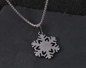 Gedetailleerde macro van een matte zilveren sneeuwvlok hanger aan een box-ketting