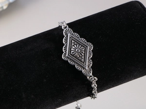 Dettaglio del bracciale vintage in argento con intricati motivi floreali in rilievo