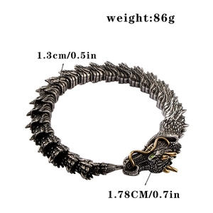 Close-up of vintage punk dragon bracelet with gold accents and detailed scales and eyes