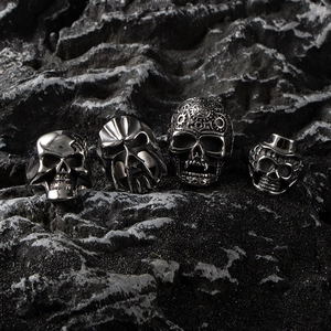 Polished gothic skull rings for men in vintage stainless steel on dark rock background