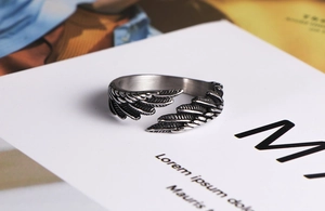 Dettaglio macro del design a piuma retrò su anello regolabile in acciaio inox