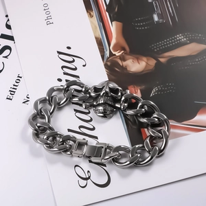 Close-up of punk style skull charm and Cuban link chain on a titanium steel bracelet