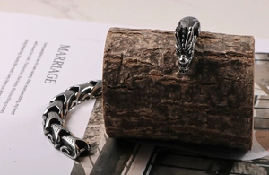 Detailed close-up of a vintage dragon head clasp and textured scales on a steel bracelet