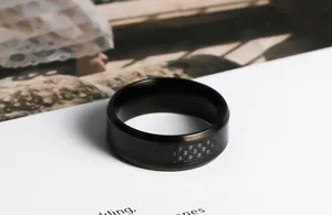 Gros plan sur une bague en acier inoxydable noir avec texture tissée en carbone