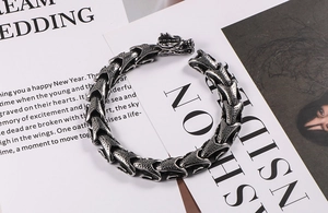Macro detail of vintage dragon head clasp and scales pattern on punk titanium steel bracelet